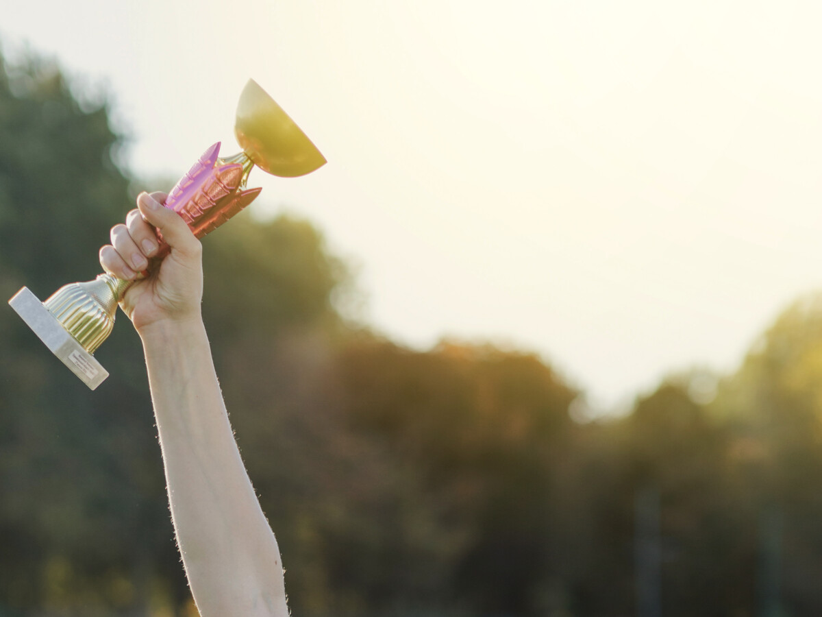 Bras tendu avec un trophée dans la main